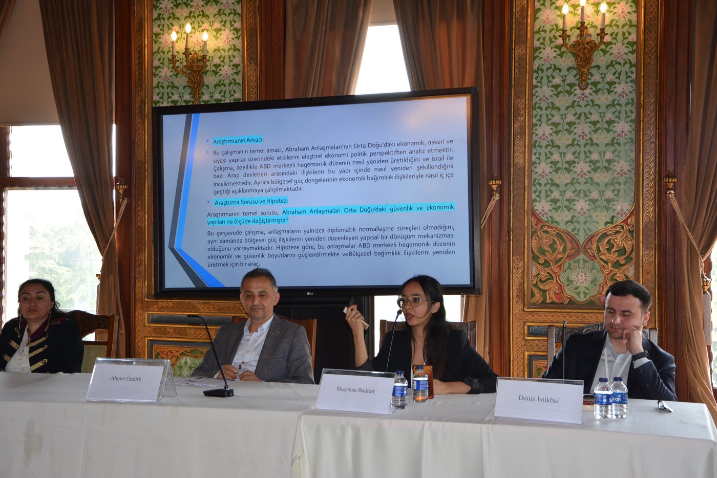 Panelde dört konuşmacı, sunum ekranda