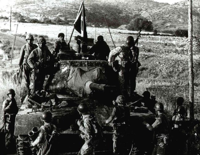 Bir tankın üzerinde duran askerleri gösteren tarihi bir fotoğraf