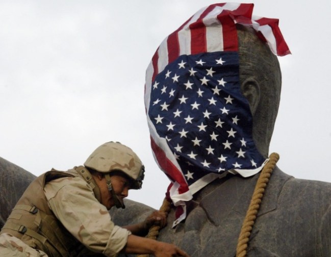 ABD askeri, Saddam Hüseyin heykelinin başını Amerikan bayrağıyla örtüyor