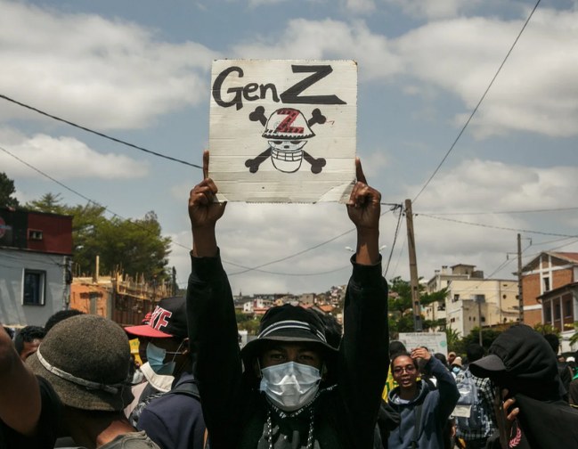Gen Z yazılı bir dövizi havaya kaldıran protestocu